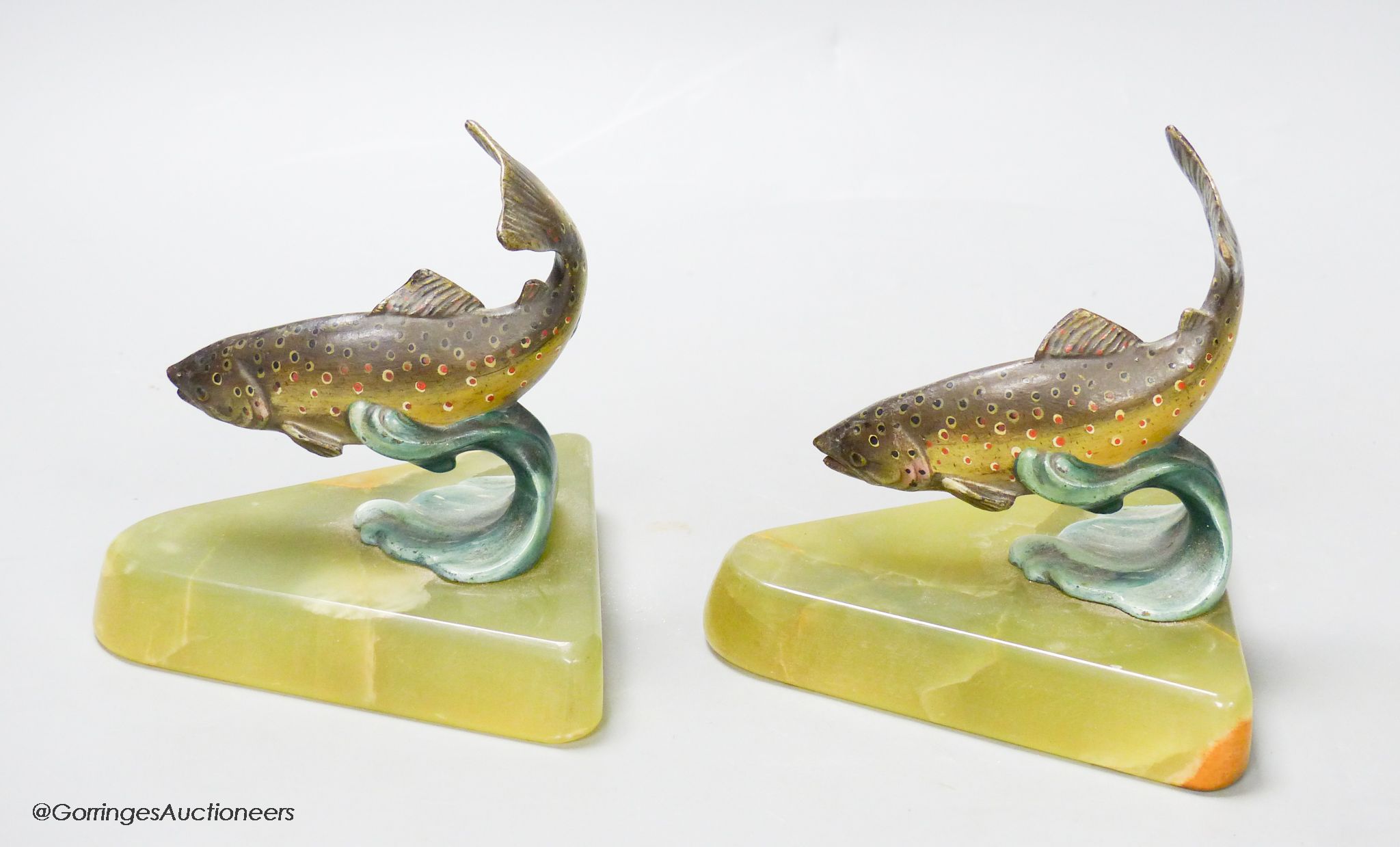 A pair of cold painted bronze fish bookends, on onyx bases, height 12cm